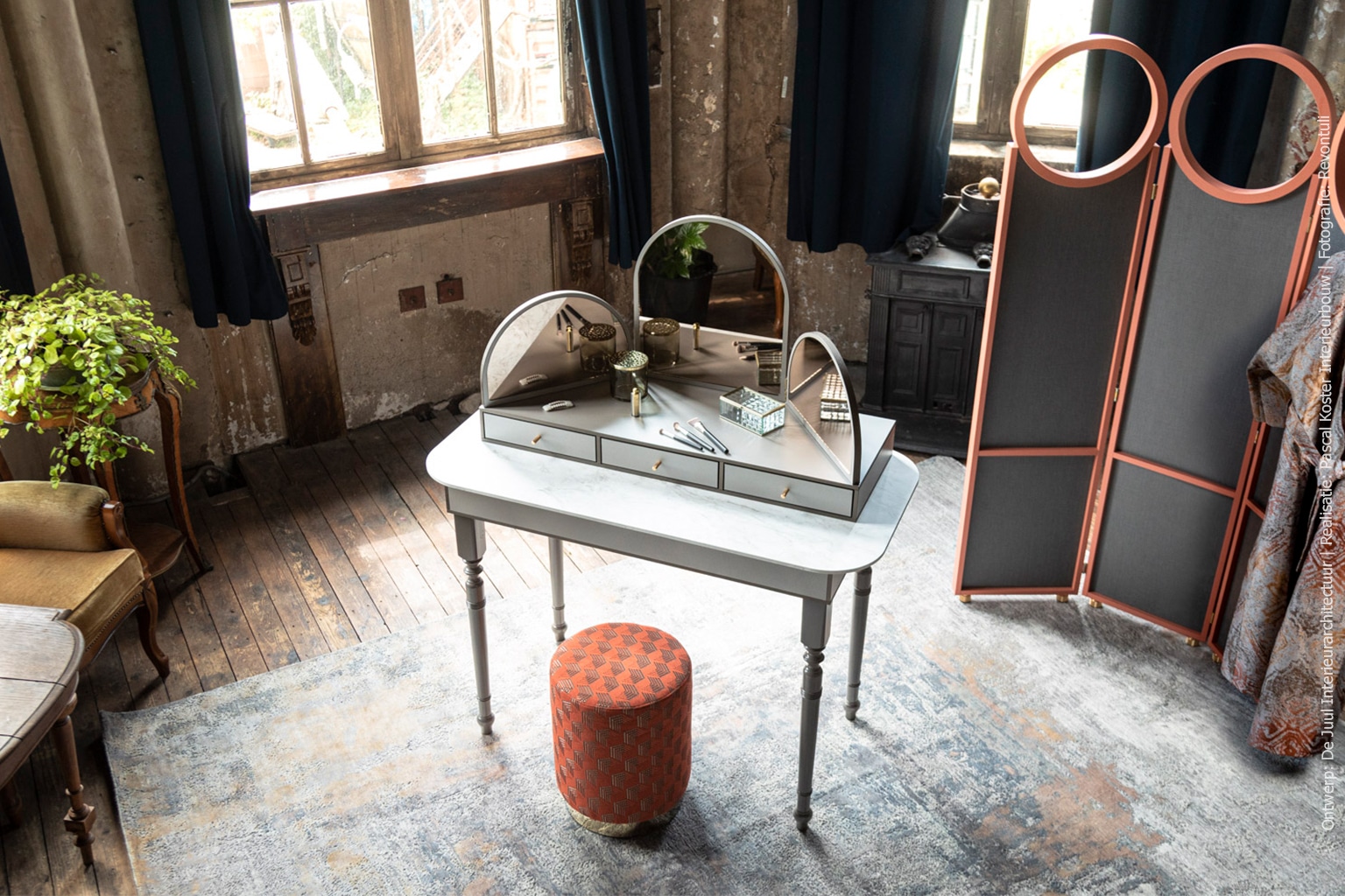 Kaptafel en kamerscherm met poef in rustieke omgeving