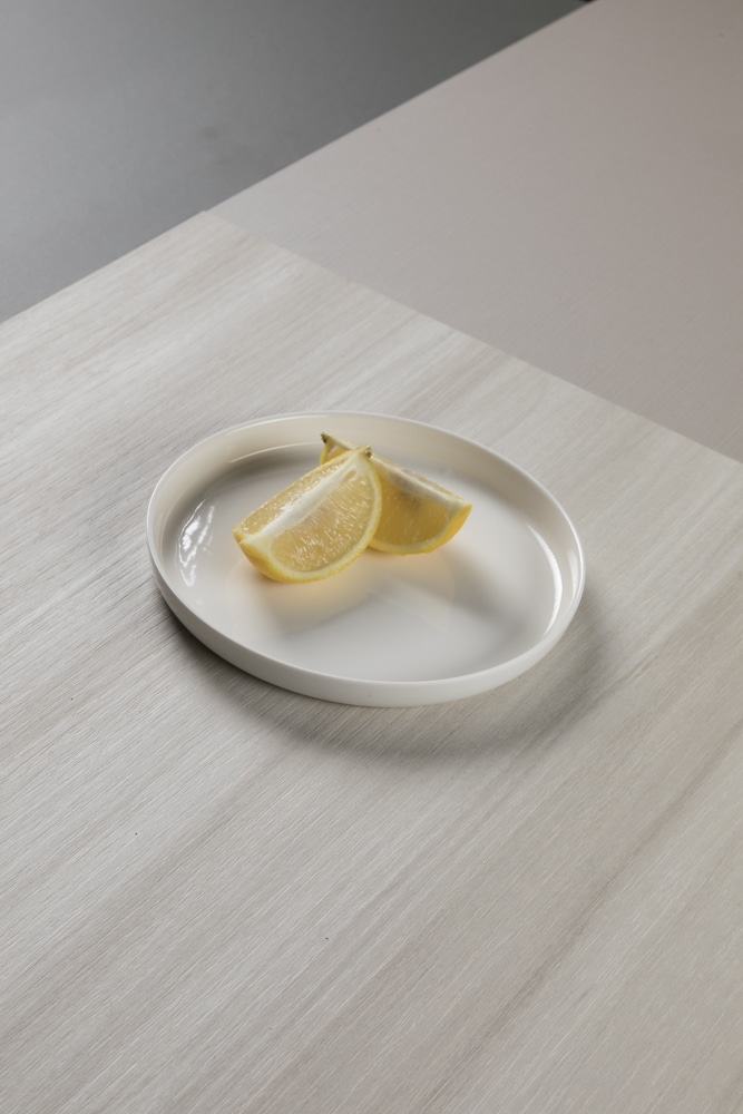 product Inspiratiebeeld lichte kleur decoratief plaatmateriaal, lijkend op wilgenhout, schaaltje met citroenpartjes