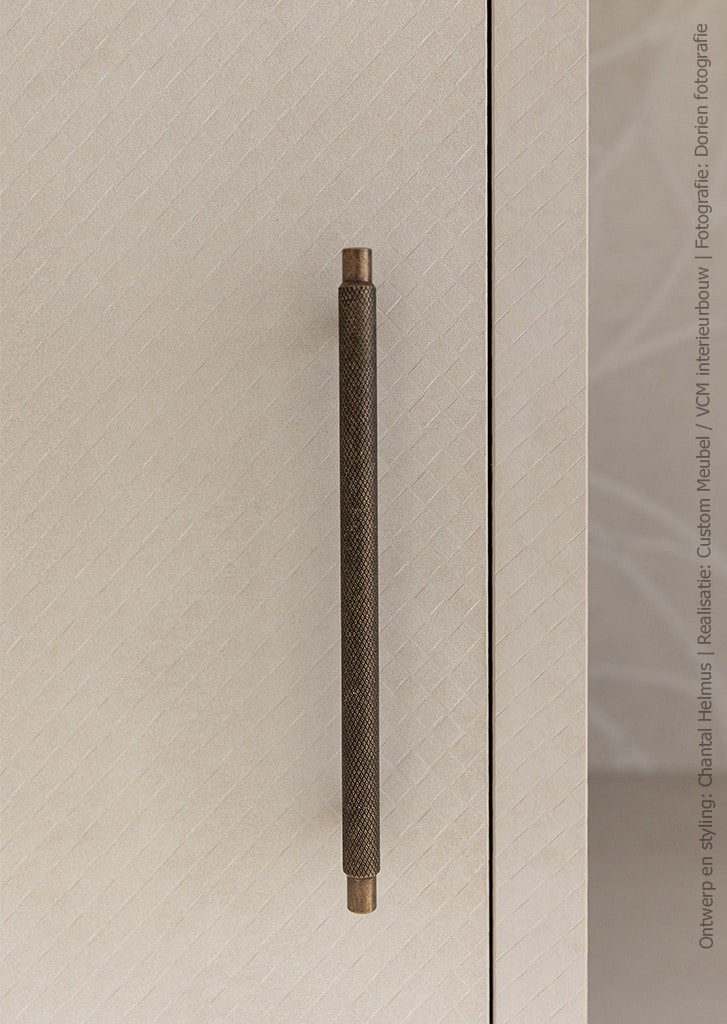 Detailafbeelding van een kast, uitgevoerd in de FB45 Mosaico van Cleaf welke is geïnspireerd op het tijdloze design van luxe lederwaren, en gouden hendel 