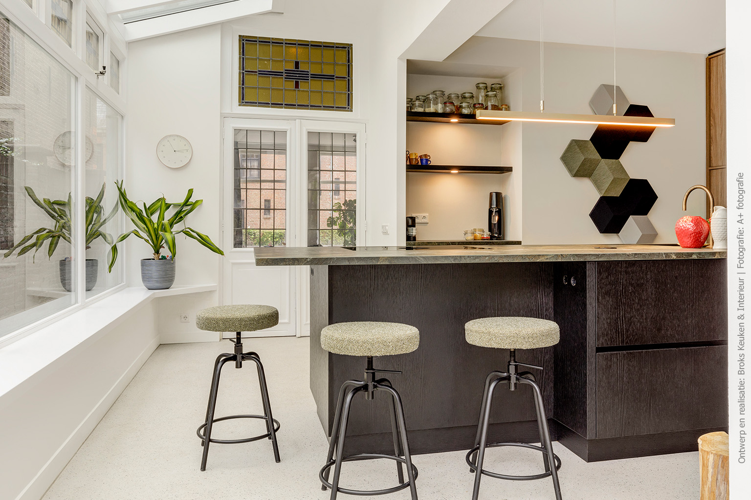 Hoge keukenkasten afgewerkt met walnoothoutdecor LS40 Poro Noce, gecombineerd met een kookeiland in zwart houtdecor U129 Quercia