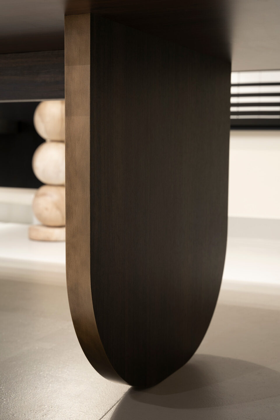 Closeup van een ronde tafelpoot in decoratief plaatmateriaal LR29 Sablé in donkerbruin met metalfinish rand