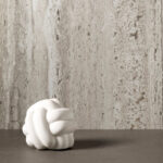 Sfeerafbeelding van decoratief plaatmateriaal FD01 Taranta met de uitstraling van travertin. Met decoratieve accesoire