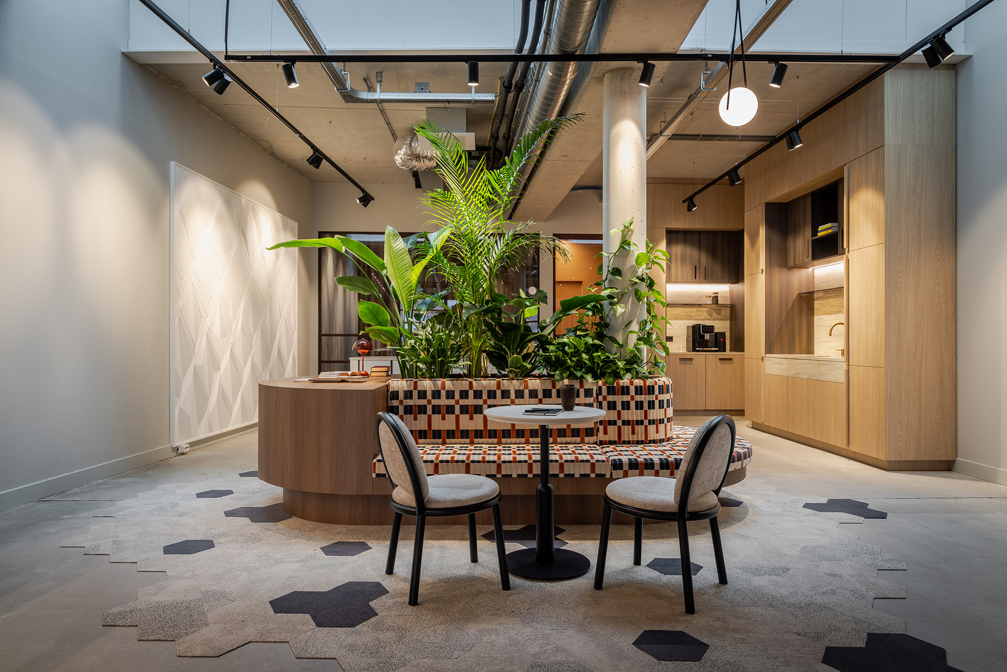 Zithoek met opvallende stof in blokmotief blauw en rood met koffietafeltje en twee stoeltjes en binnentuin met groene planten