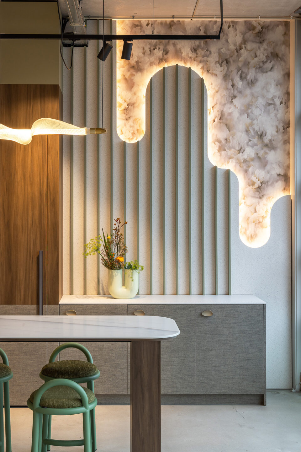 Maatwerkkast met sprekende achterwand met groene latjes, ledverlichting en bloemenbehang en golvende vormen