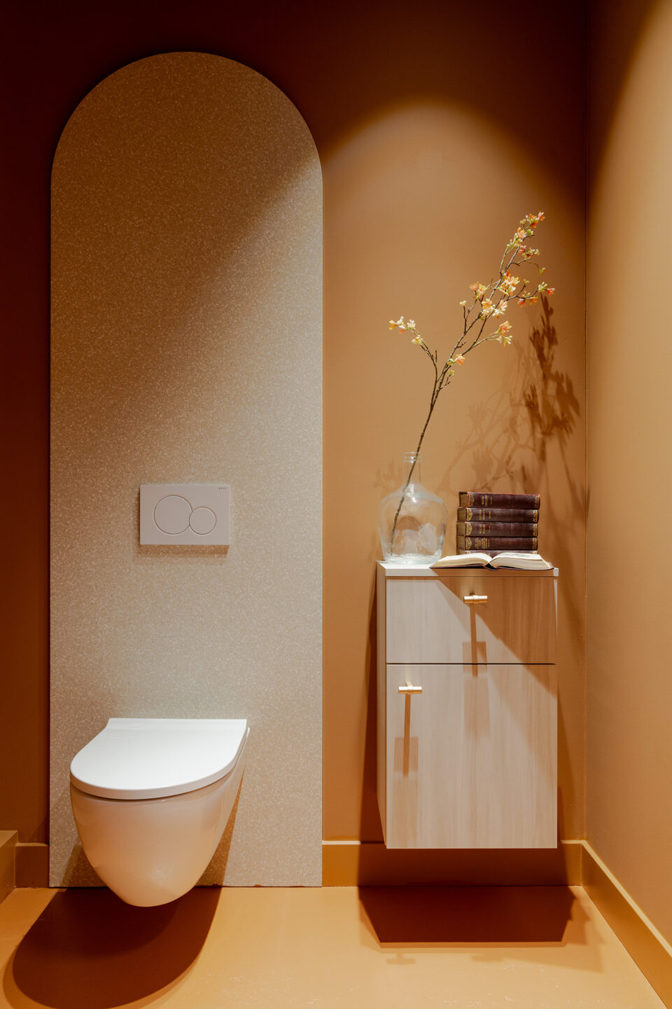 Toilet met organische vorm als achterwand, wastafel en decoratieve tak