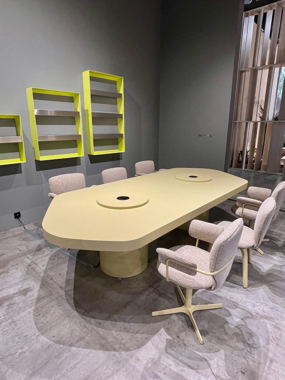 Pastelkleurige tafel met stoelen en wanddecoratie in beursstand met grote lamp