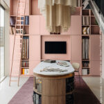 Stijlvolle showroomopstelling met vakkenkast in poederroze UB52 Ovatta, gecombineerd met een walnoot werktafel in LS40 Poro Noce en een Durasein werkblad met marmerlook.