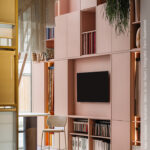 Stijlvolle showroomopstelling met vakkenkast in poederroze UB52 Ovatta, gecombineerd met een walnoot werktafel in LS40 Poro Noce en een Durasein werkblad met marmerlook.