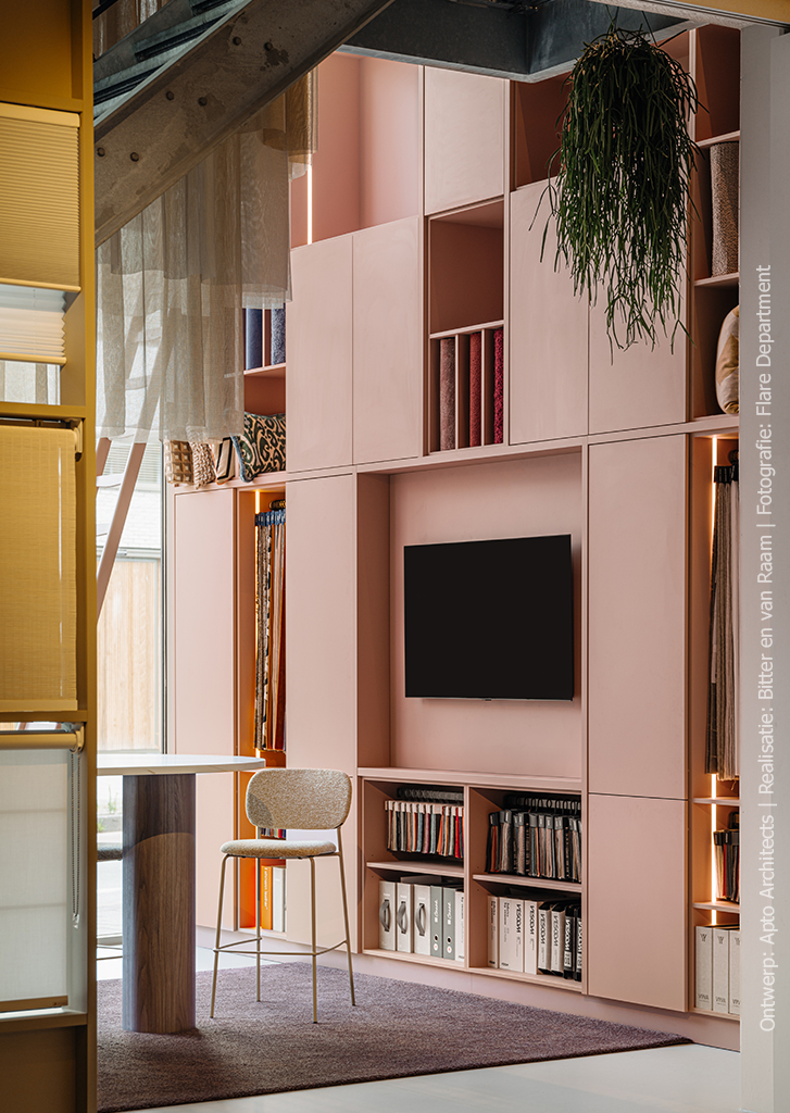 Stijlvolle showroomopstelling met vakkenkast in poederroze UB52 Ovatta, gecombineerd met een walnoot werktafel in LS40 Poro Noce en een Durasein werkblad met marmerlook.