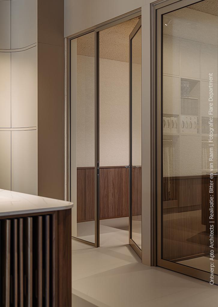 Stijlvolle showroomopstelling met vakkenkast in poederroze UB52 Ovatta, gecombineerd met een walnoot werktafel in LS40 Poro Noce en een Durasein werkblad met marmerlook.