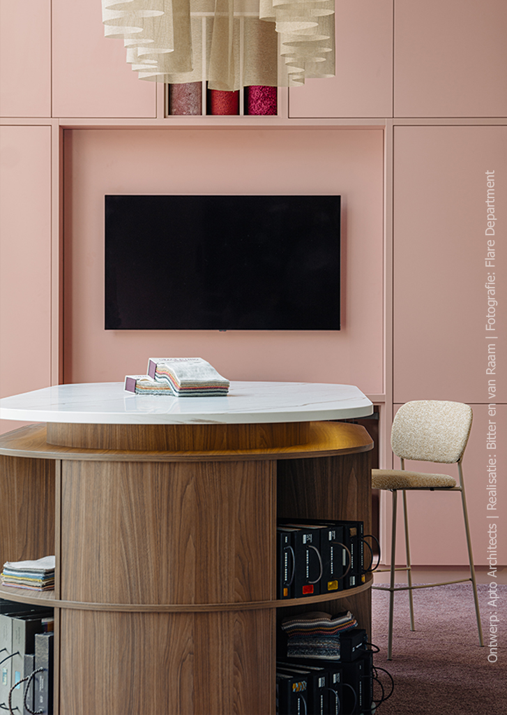 Stijlvolle showroomopstelling met vakkenkast in poederroze UB52 Ovatta, gecombineerd met een walnoot werktafel in LS40 Poro Noce en een Durasein werkblad met marmerlook.