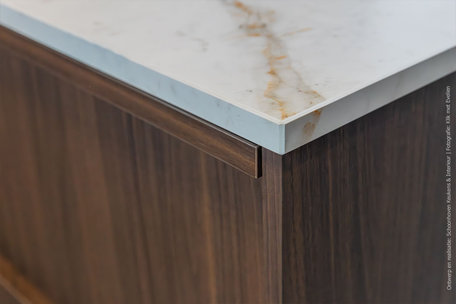 Detailfoto van kookeiland in de mat donkerbruine LS17 Poro Noce met levendige walnotenhoutstructuur.