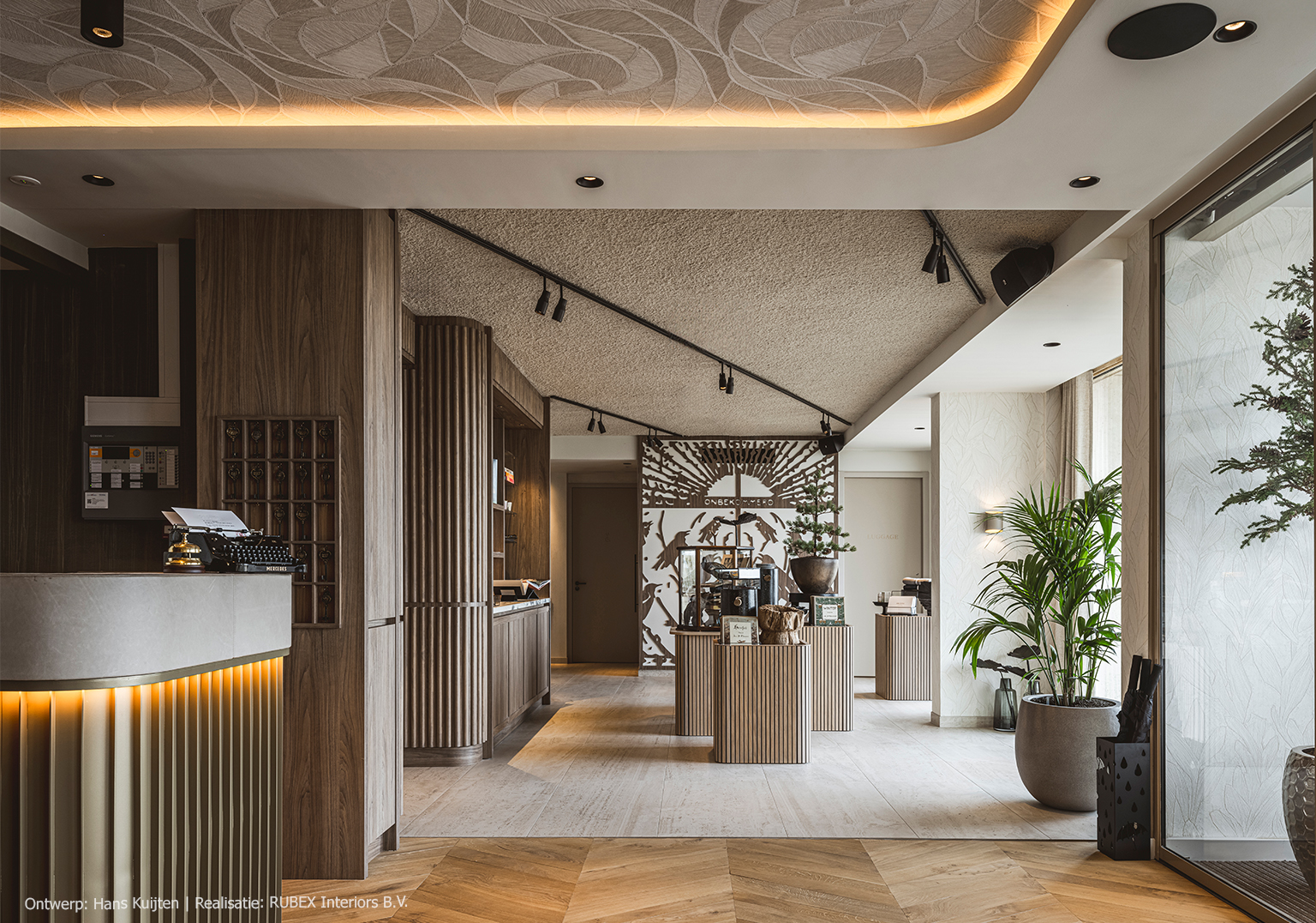 Maatwerk in de entree van een hotel, uitgevoerd in LS13 Poro Noce, een warm lichtbruin walnootdecor met levendige nerftekening.